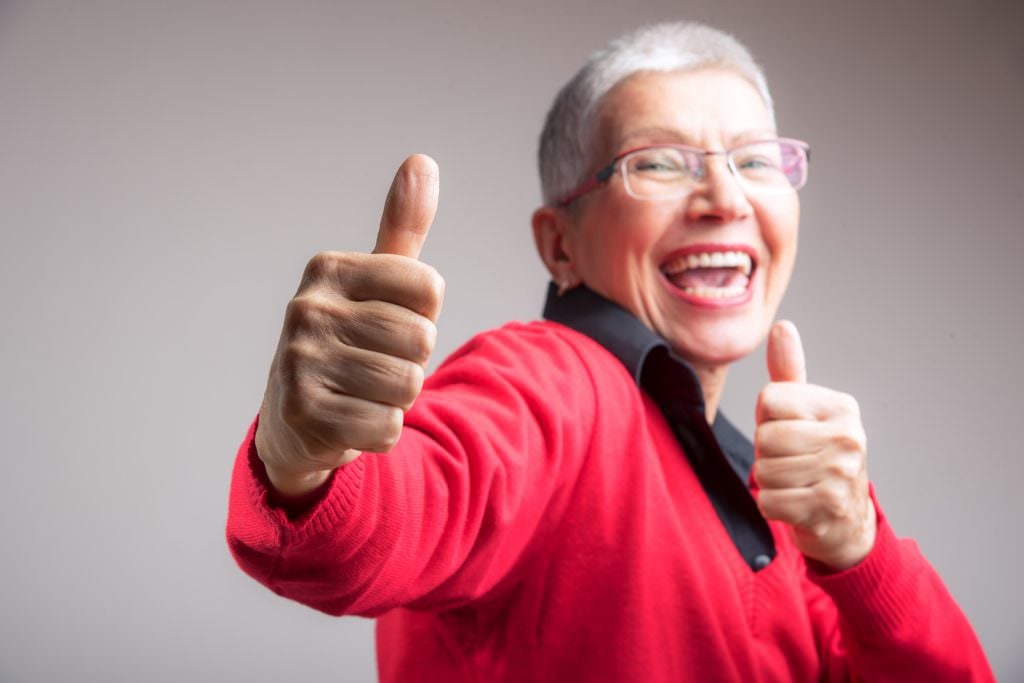 Happy senior old lady giving thumbs up, supporting your decision fully